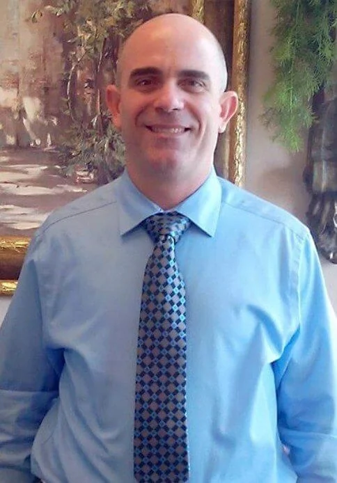 Dr. Javier Perez, DDS, in a light blue shirt and tie at Times Square Family Dental.