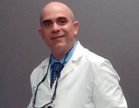 Dr. Javier Perez in a white coat.
