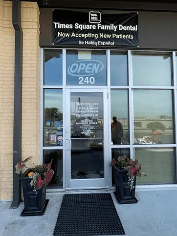 The glass door of Suite 240 with an OPEN sign and a banner reading Times Square Family Dental, Now Accepting New Patients.