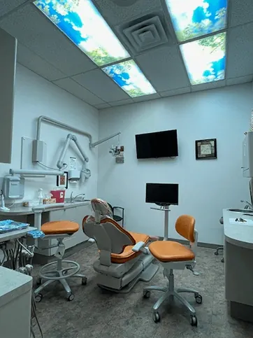 A treatment room at Times Square Family Dental, with a monitor on the wall facing the chair.