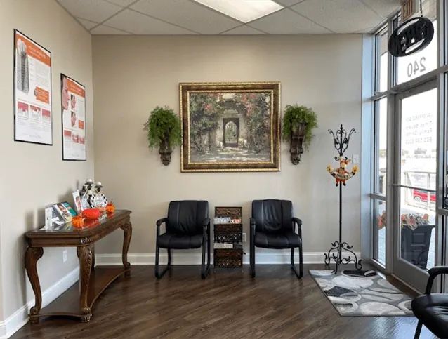 The waiting area at Times Square Family Dental: leather chairs, a side table and a framed painting.